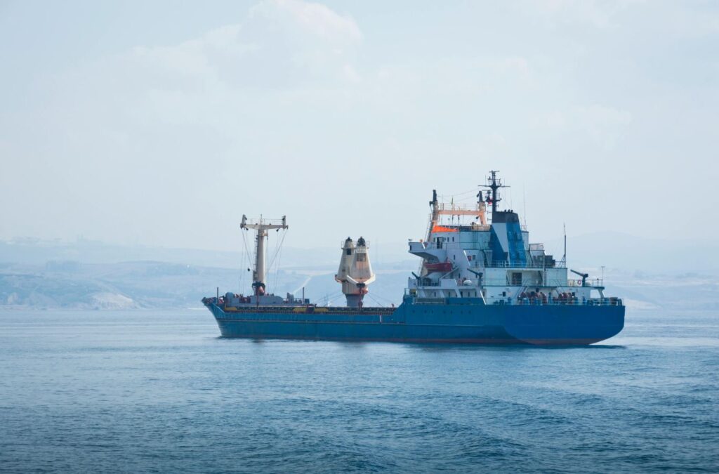 Marine facility staff receiving AUS40 supply beside organized dockside storage area